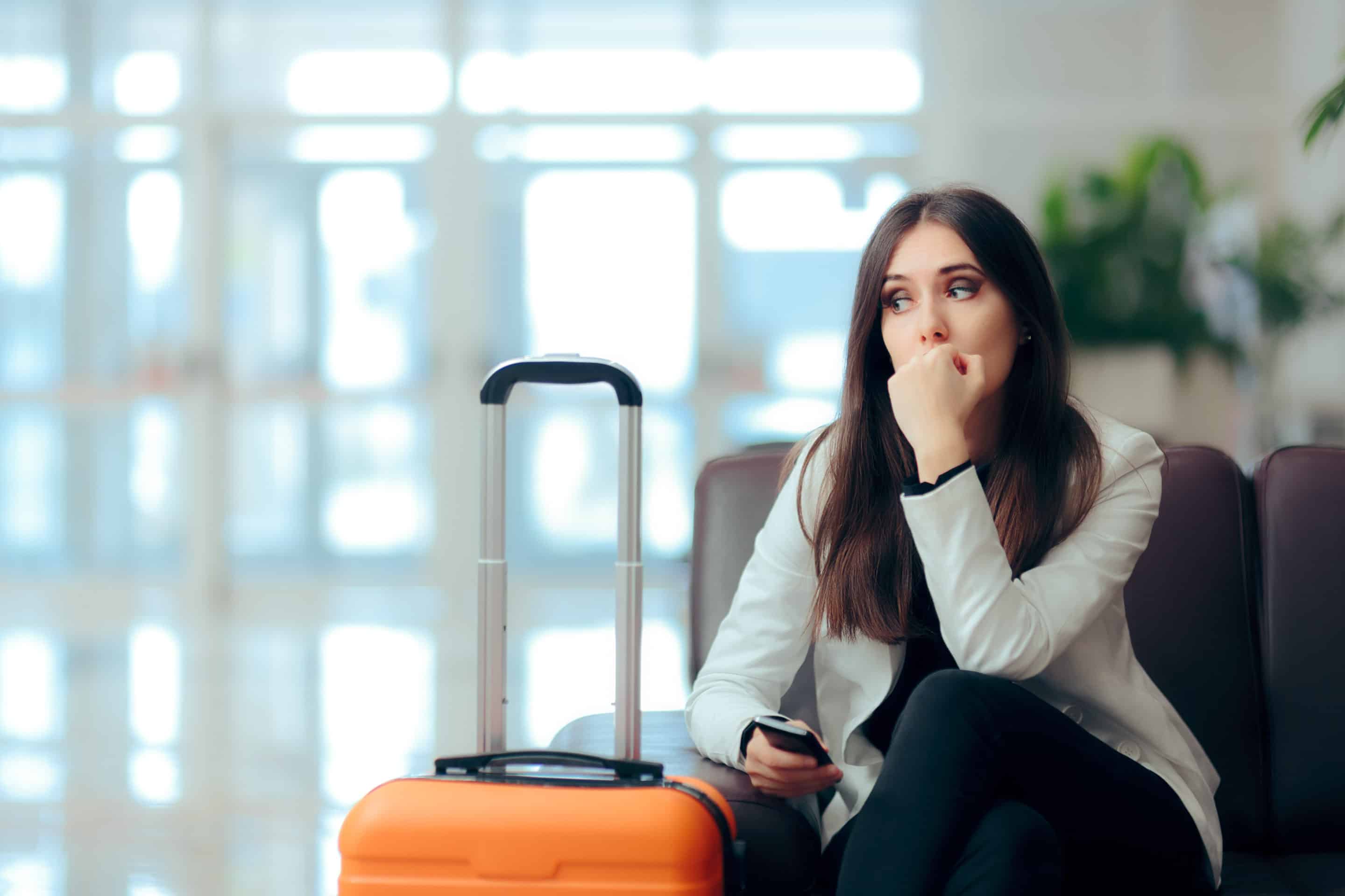 Femme assise avec une valise, incarnant la difficulté émotionnelle de prendre la décision de quitter un environnement nocif.