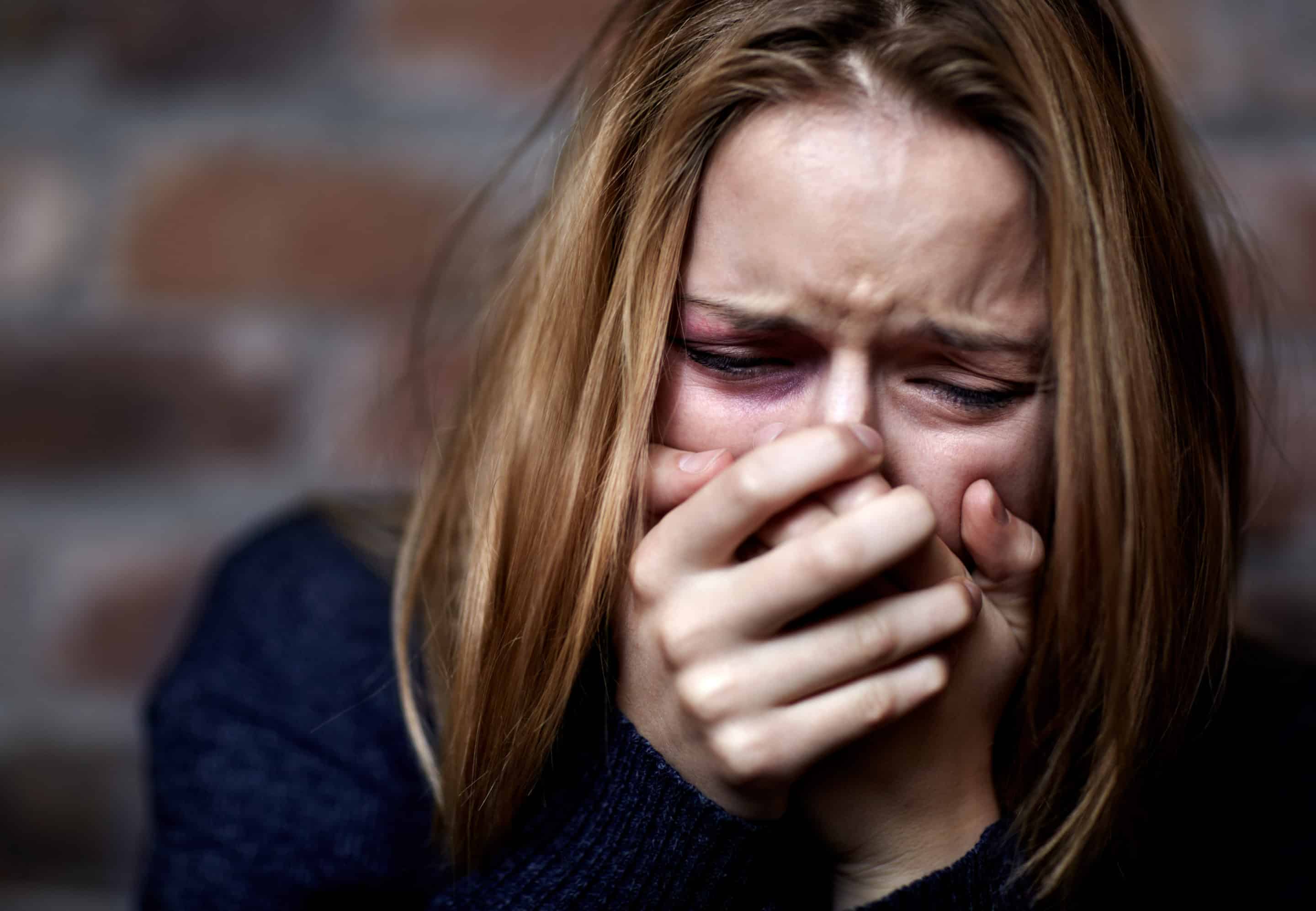 Jeune femme angoissée avec des signes de détresse, symbolisant l’emprise du pouvoir par la peur.