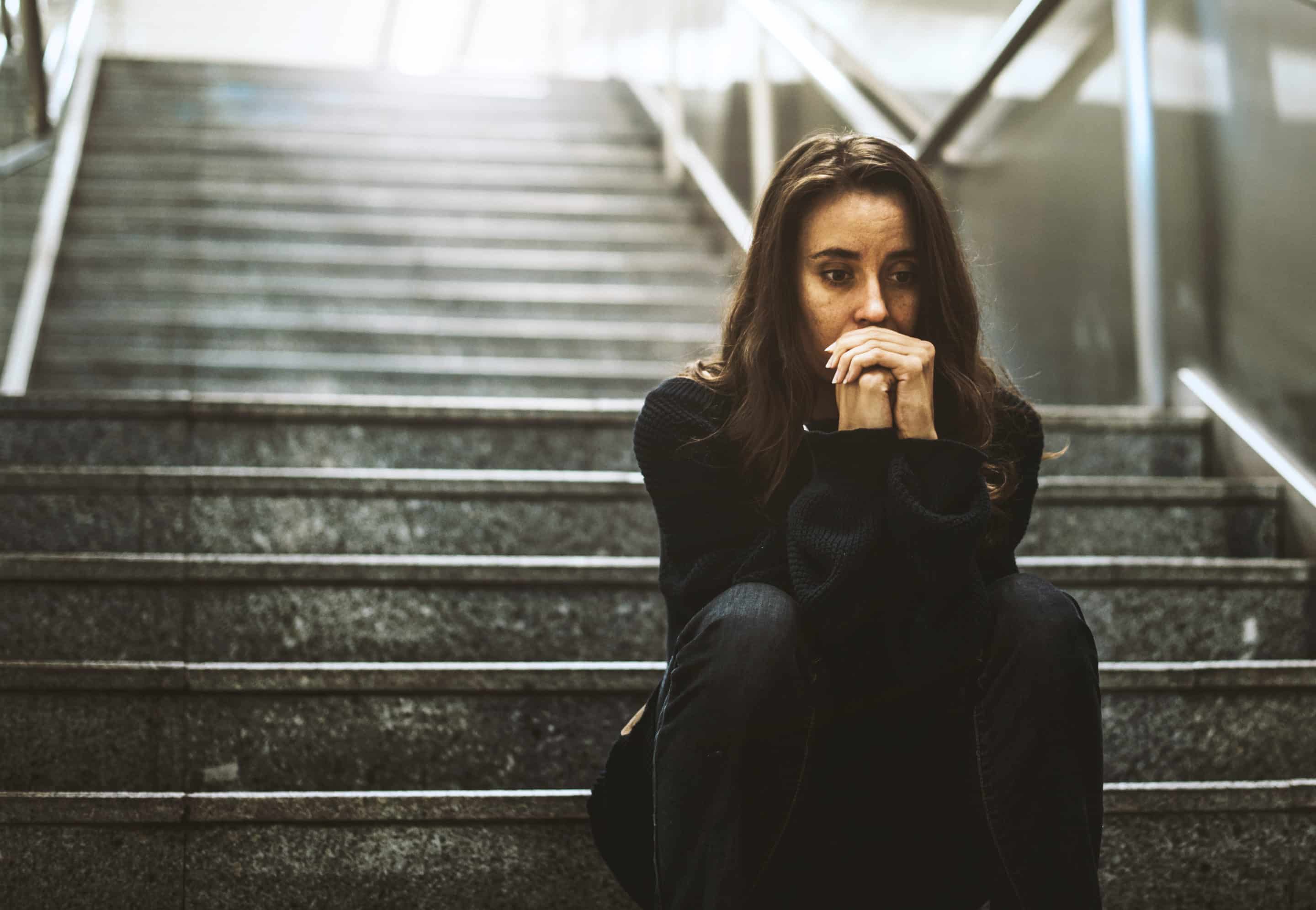 Photo d’une femme assise sur des marches, reflétant la tristesse et la réflexion liée au deuil des bons moments vécus avec un pervers narcissique.