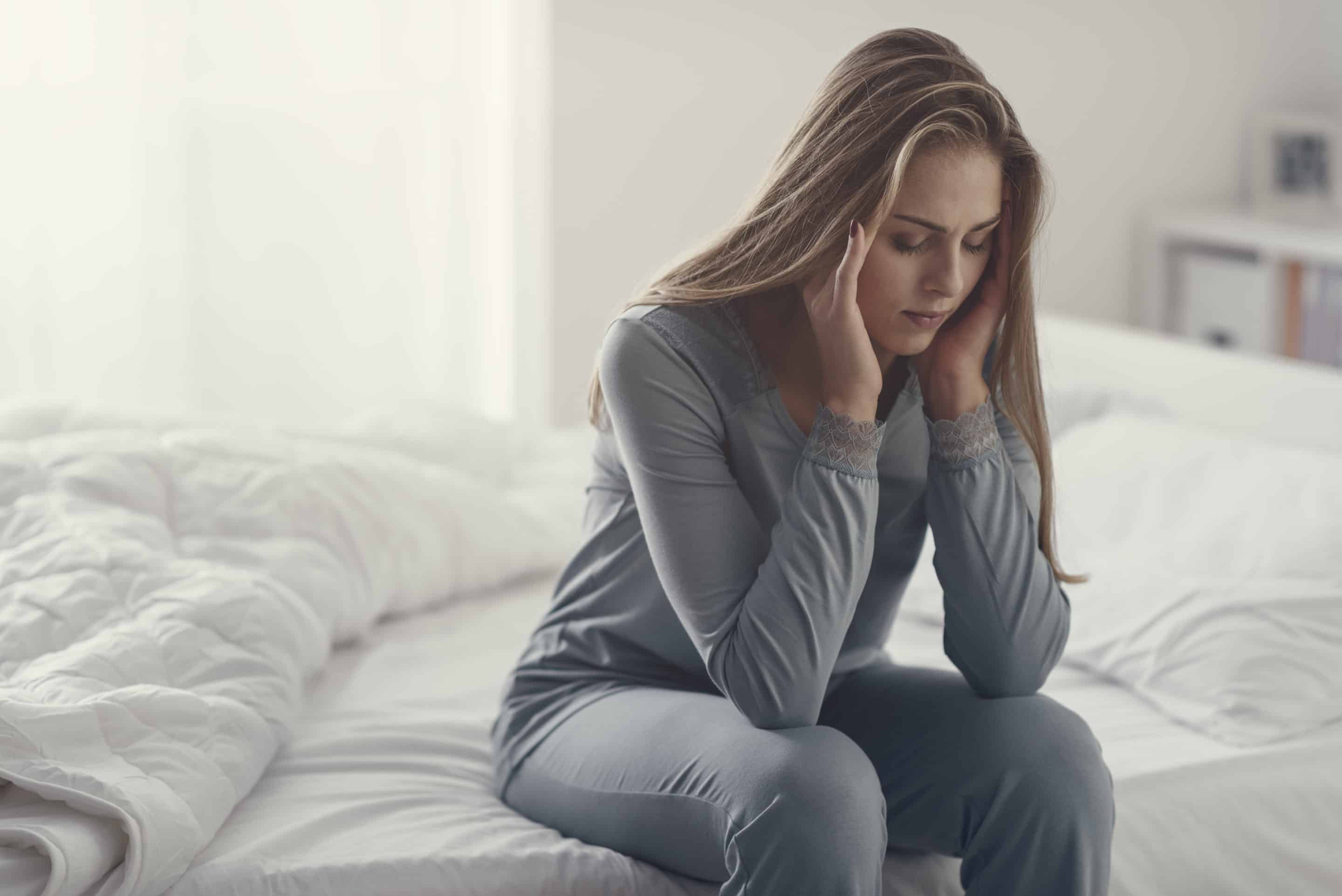 Femme préoccupée, isolée dans une chambre, symbolisant les conséquences des troubles de l'attachement dans une relation avec un pervers narcissique.